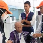Petugas kesehatan memeriksa suhu tubuh jemaah haji yang baru tiba di bandara sebagai langkah deteksi dini penyebaran Covid-19.